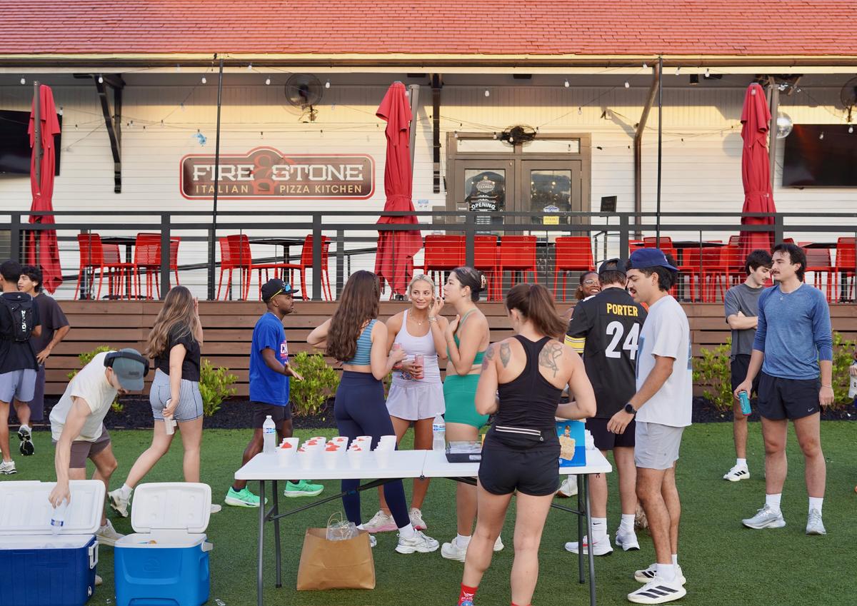 Runners gathered around the water and snack table on the turf outside Fire Stone in downtown Woodstock before a Sunday run